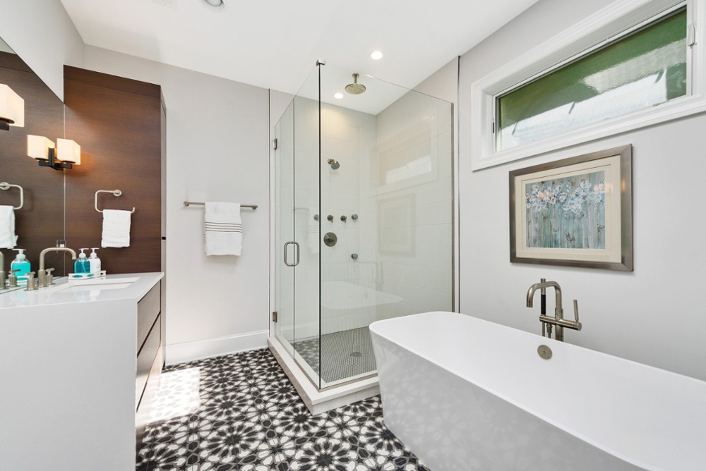 Remodeled bathroom with tile floors and standing tub