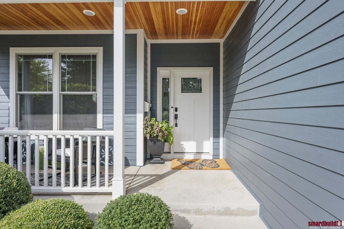 Exterior front porch with wood ceiling and blue siding