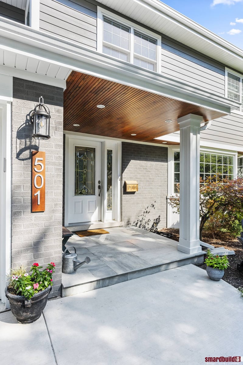 Exterior of home front entry door with wood porch ceiling