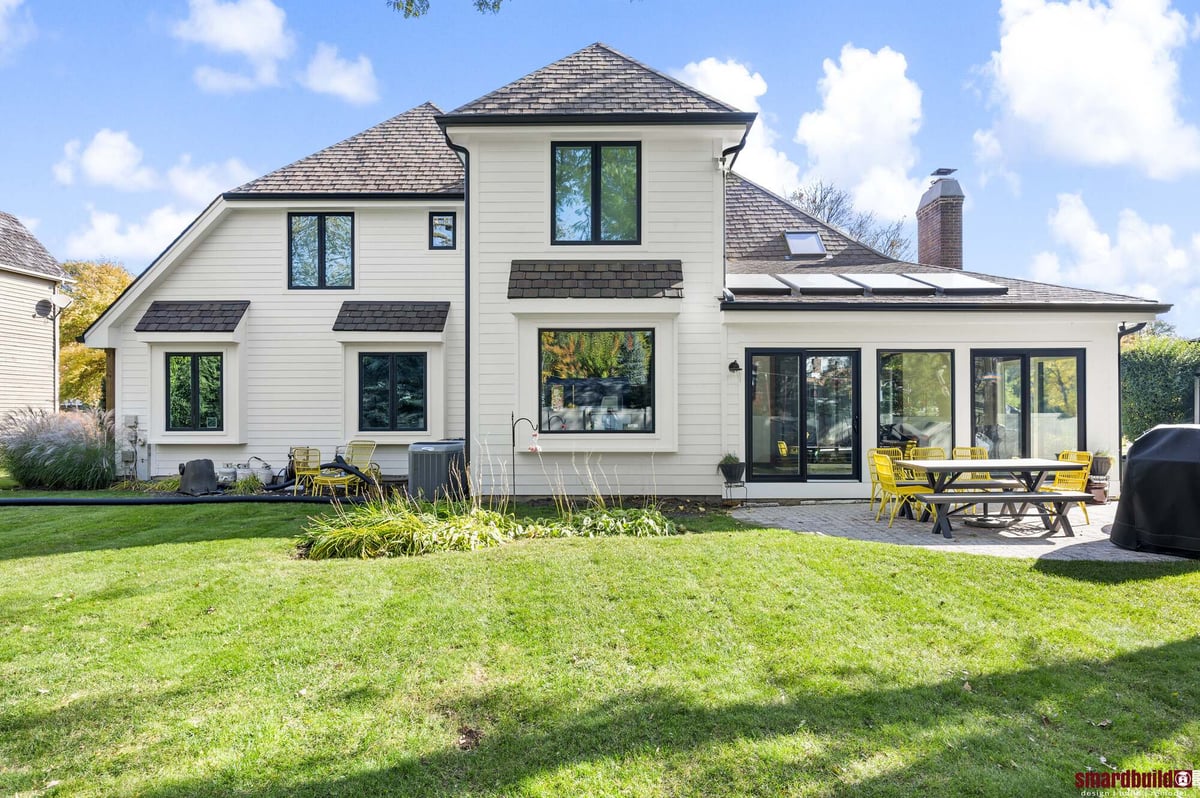 Backyard exterior view of home with white siding and black trim